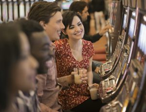 A group of people playing the slot machines in a casino.